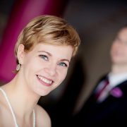 schickes Portrait der Braut mit Bräutigam unscharf im Hintergrund