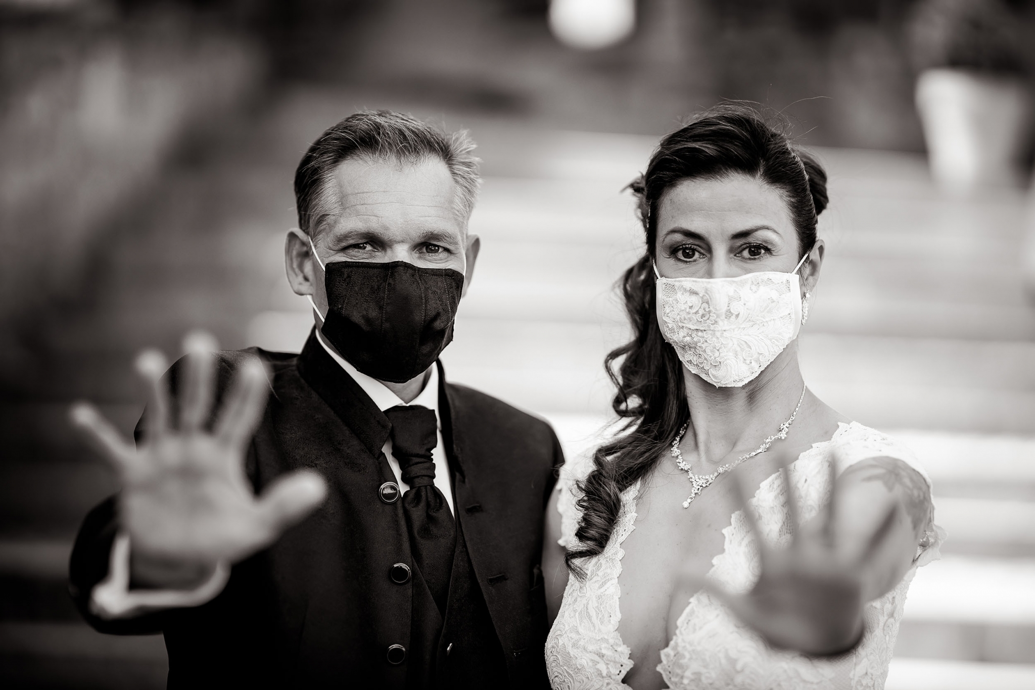 Braut & Bräutigam tragen einen Mundschutz und halten die Hände abwehrend Richtung Kamera Canon EOS R & RF 85mm