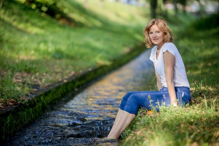 Ganzkörperaufnahme der Yogalehrerin Monika Freeman, Füße im Wasser baumelnd, frische Sommerfarben Canon EOSR6 & EF 135mm f2.0L USM