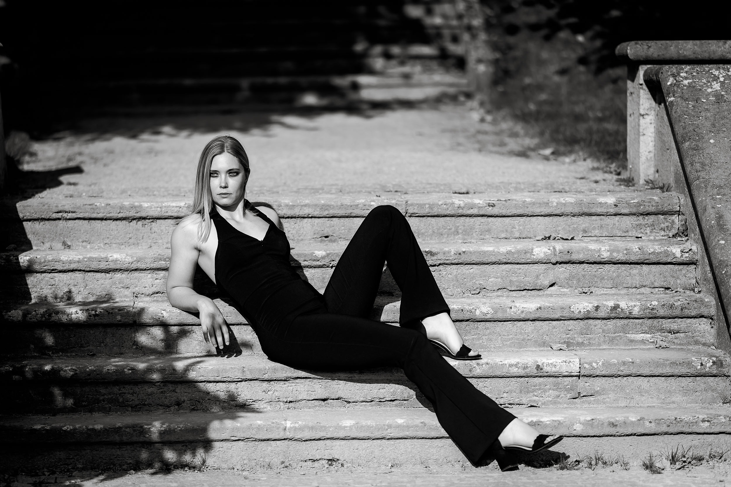 Das zeitlose Styling der Frau erinnert an die Ästhetik von Chanel, schlichte und zeitlose Eleganz in klassischen schwarz weiss, fotografiert im harten Sonnenlicht in Bad Langensalza mit der Canon EOS R5 MK2 & dem RF 135mm f1.8