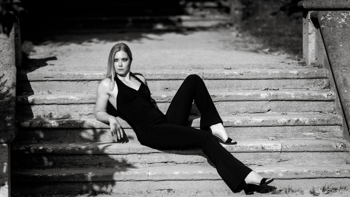 Eleganz in Schwarz Das zeitlose Styling der Frau erinnert an die Ästhetik von Chanel, schlichte und zeitlose Eleganz in klassischen schwarz weiss, fotografiert im harten Sonnenlicht in Bad Langensalza mit der Canon EOS R5 MK2 & dem RF 135mm f1.8