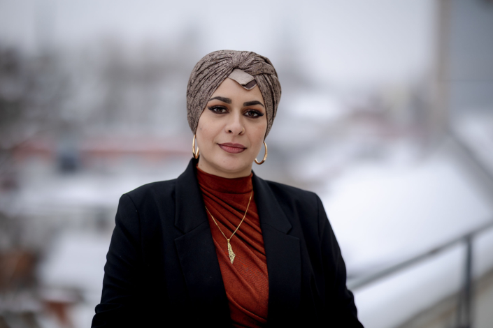 Ausdrucksstarkes Porträt einer eleganten Frau vor winterlicher Kulisse Portrait einer eleganten Frau mit kunstvoller Kopfbedeckung, Creolen und einer markanten Halskette in einer verschneiten Umgebung. Das Bild besticht durch eine geringe Schärfentiefe fotografiert in Erfurt mit der Canon EOS R6 & dem RF 85mm f1.2