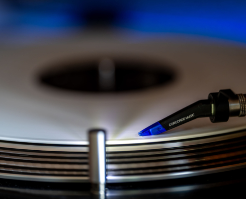Nahaufnahme eines Ortofon Concorde Music Blue Tonabnehmers, der auf einer rotierenden weißen Vinylplatte auf einem Reloop RP 700MK2 aufliegt.