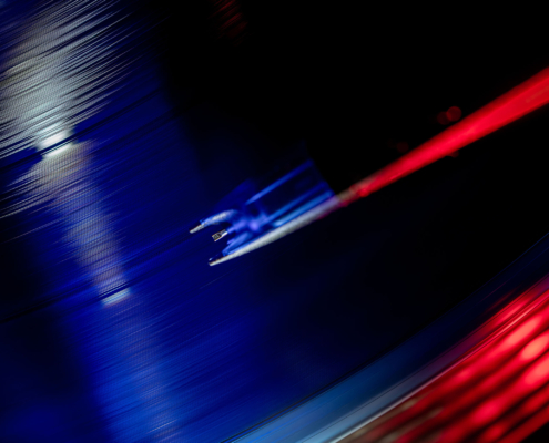 Detailansicht des Tonabnehmers beim Abspielen einer blauen Schallplatte.