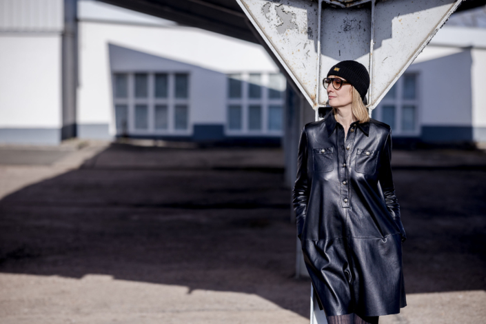 Urbanes Portrait in Erfurt im Leder Look Urbanes Streetstyle Mode-Porträt einer Frau mit Sonnenbrille und schwarzem Leder-Look in einem Industriegebiet.